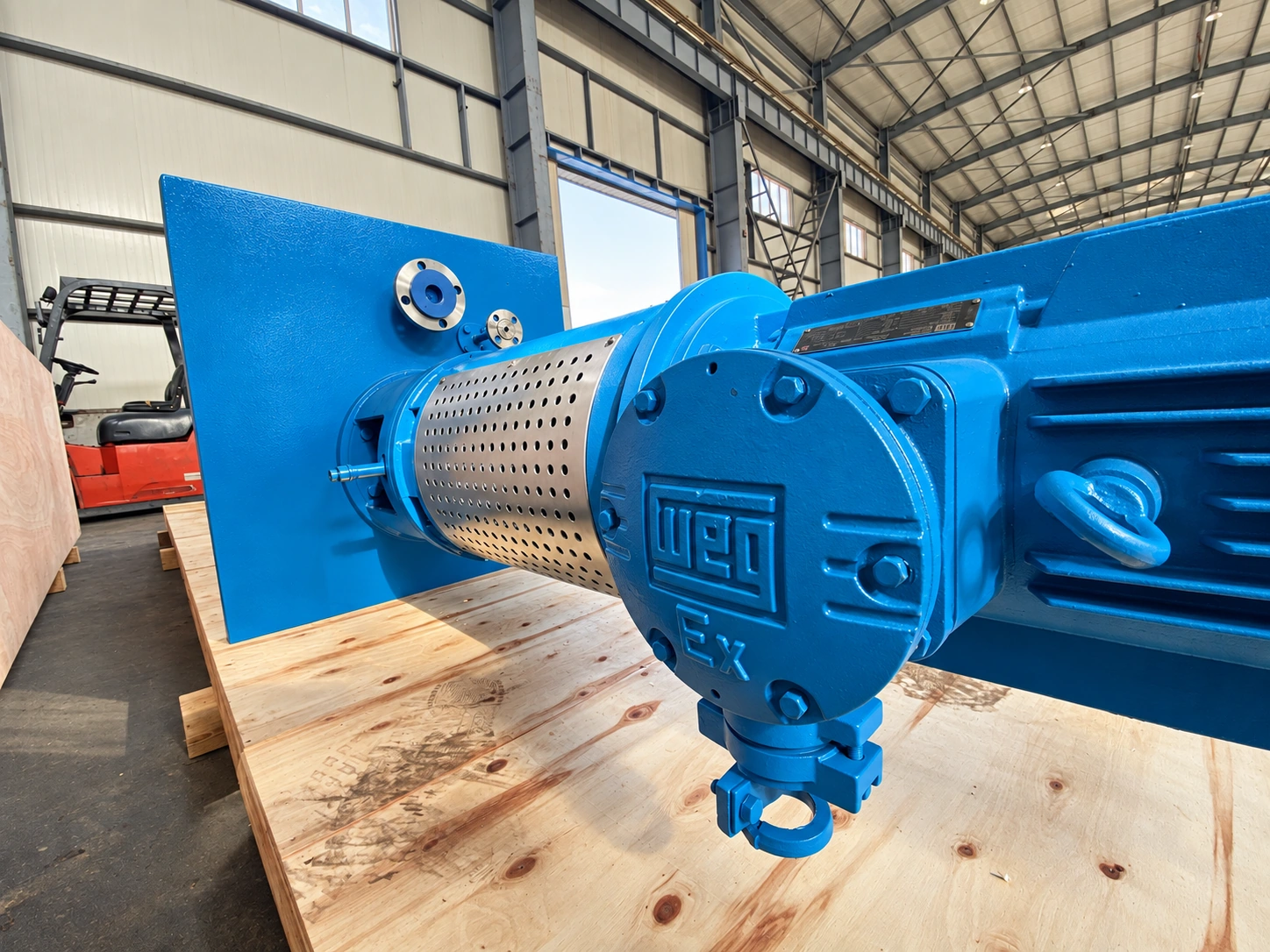 Vue rapprochée du moteur bleu et du carter d’accouplement argenté.