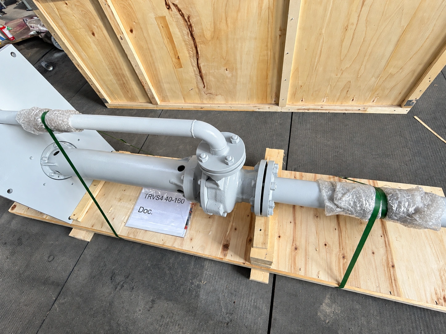Vue rapprochée de la colonne de pompe et de la conduite de refoulement séparée sur des supports en bois.